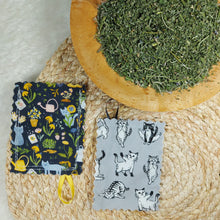 Load image into Gallery viewer, 100% cotton fabric. Each pouch measures 3” x 4” with edges finished using pinking shears to reduce fraying. Double stitched for extra durability to withstand vigorous play. Includes a 1” loop of securely attached ribbon allowing it to be attached to a string for an additional mode of play. Contains 4 grams of catnip and catmint grown and dried in St. Jacobs, ON. Hanging your catnip pouch to dry after each use will ensure many months of use. Wiggles and Whiskers Canada Pet Accessories.