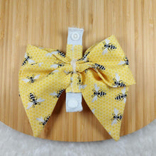 Load image into Gallery viewer, Collar Bow - Bees! Pet collar can be worn as a cat collar or dog collar. Help your pup put their best paw forward by wearing one of these pretty bows on their collar. Worn to the side, up front or at the back, its versatility makes dressing up an everyday possibility! Measures 5.5” at its widest point. Made from 100% cotton fabric in a variety of patterns. Fastens to collars up to 1” wide. Elastic and snap fastener. Wiggles and Whiskers Canada Pet Accessories.