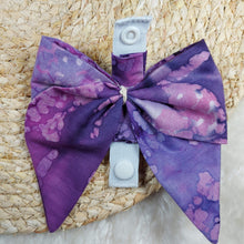 Load image into Gallery viewer, Purple perfection bow collar. Help your pup put their best paw forward by wearing one of these pretty bows on their collar. Worn to the side, up front or at the back, its versatility makes dressing up an everyday possibility! This collar bow is suitable as a cat collar and a dog collar. Measures 5.5” at its widest point. Made from 100% cotton fabric in a variety of patterns. Fastens to collars up to 1” wide. Elastic and snap fastener. Wiggles and Whiskers Canada Pet Accessories.