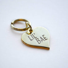 Load image into Gallery viewer, Gold Plated L'il Bae Pet Tag. Our pets get 100% of our affection - which is exactly why Canadian company Boldfaced Goods decided to make these cute Lil' Bae pet tags. Measures almost 1 inch in size. Shiny backing perfect for engraving their name/number. Can also be worn as a pendant necklace for humans. Gold plated zinc alloy. Wiggles and Whiskers Canada Pet Accessories.