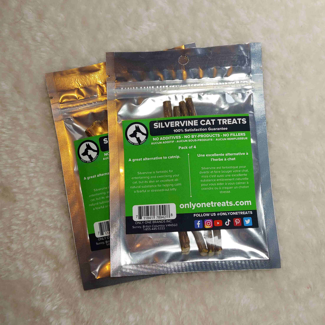 2 vacuum sealed packages of Silvervine Cat Treats with a green and black label on them laying on a off white background. 