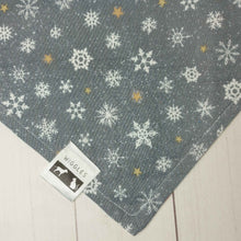 Load image into Gallery viewer, Dog Bandana made out silver fabric with snowflakes on it laying flat on a white background .
