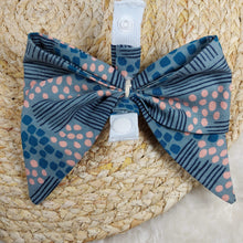Load image into Gallery viewer, Abstract Teal with Pink Collar Bow. Help your pup put their best paw forward by wearing one of these pretty bows on their collar. Worn to the side, up front or at the back, its versatility makes dressing up an everyday possibility! This collar bow is suitable as a cat collar and a dog collar.  Measures 5.5” at its widest point. Made from 100% cotton fabric in a variety of patterns. Fastens to collars up to 1” wide. Elastic and snap fastener. Wiggles and Whiskers Canada Pet Accessories.
