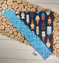 Load image into Gallery viewer, Summer Treats Snap-On Dog Bandana. This Snap-On bandana is fully reversible with two coordinating cotton fabrics. One side is a colourful collection of modern popsicles and ice-cream cones on a navy background and the other side is a bright blue fabric with white abstract lines. The Medium dog bandana is 20 inches in width and 11 inches in length. Wiggles and Whiskers Canada Pet Accessories. 
