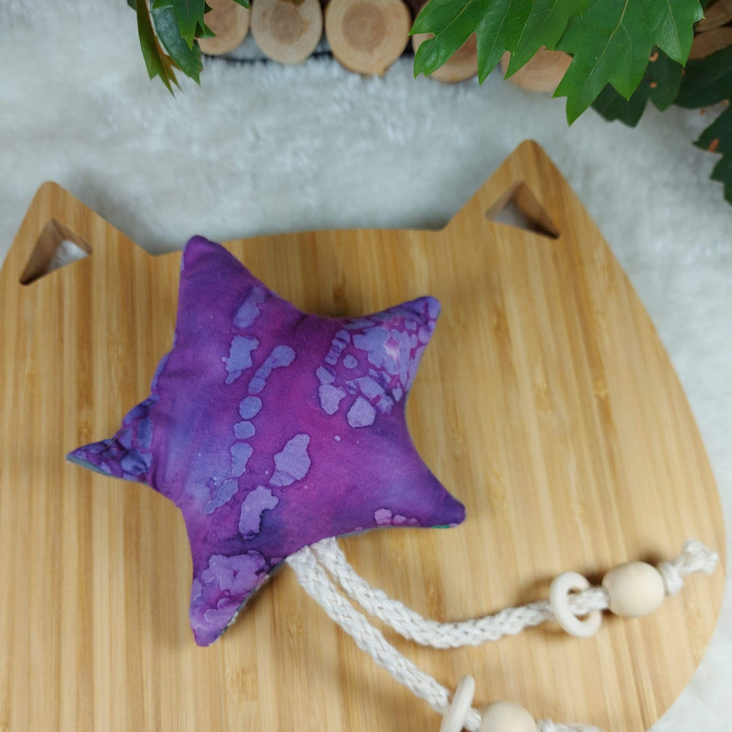 Purple Perfection Star Catnip Toy. Stimulate all your cat’s senses with this catnip toy! Star shaped flannel toy with string dangle with monkey patterns. Measures 5.5” across and 11” in total length. This catnip toy is yellow and orange on one side . The other side of this catnip toy is blue with decorative moon prints. Wiggles and Whiskers Canada Pet Accessories.